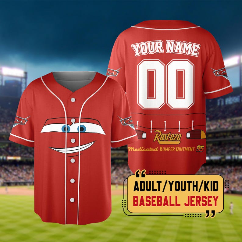 Pu&ograve; includere: Maglia da baseball rossa con la faccia di un'auto dei cartoni animati sul davanti. Il retro mostra "YOUR NAME" sopra il numero "00" e il testo "Rusteze Medicated Bumper Ointment 95". La maglia &egrave; etichettata "ADULT/YOUTH/KID BASEBALL JERSEY".