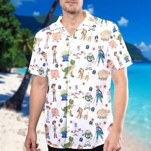 May include: White button-down shirt featuring a colorful pattern of Toy Story characters. The short-sleeved shirt has a classic collar and is decorated with images of Woody, Buzz Lightyear, and other characters from the animated film.