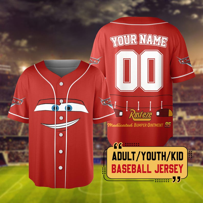 Pu&ograve; includere: Maglia da baseball rossa con la faccia di un'auto dei cartoni animati sul davanti. Il retro mostra "YOUR NAME" sopra il numero "00" e il testo "Rusteze Medicated Bumper Ointment 95". La maglia &egrave; etichettata "ADULT/YOUTH/KID BASEBALL JERSEY".