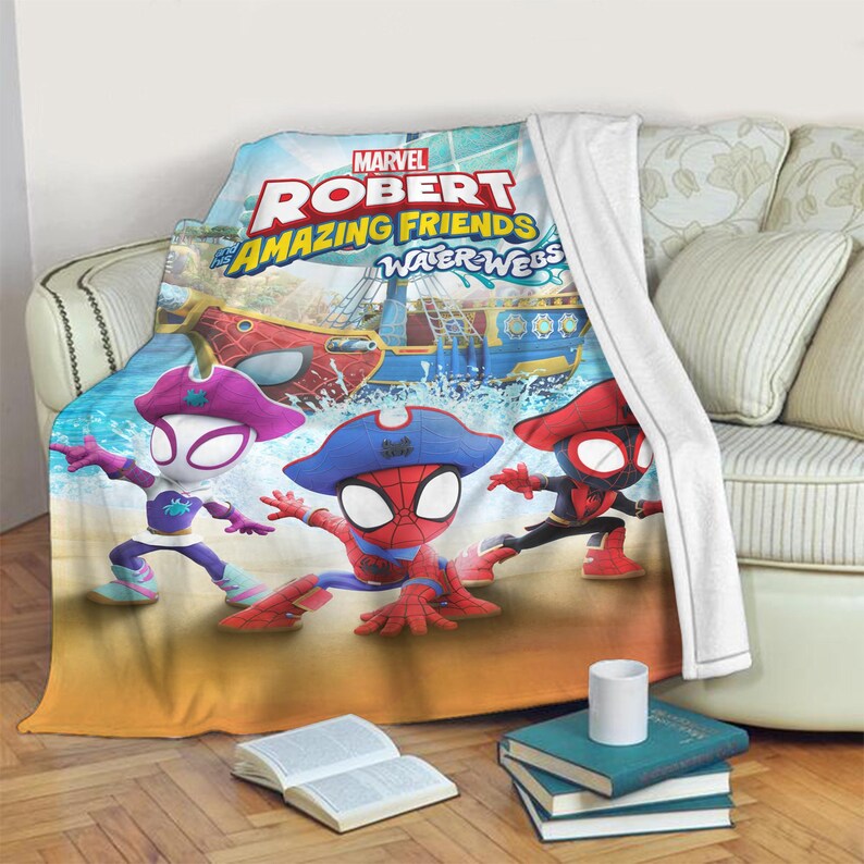 K&ouml;nnte beinhalten: Eine Marvel "Robert Amazing Friends Water Webs" Decke mit Spider-Man-Charakteren in Piratenkleidung. Die Decke hat ein farbenfrohes Design mit einem Piratenschiff und einer Meereslandschaft. Die Decke ist &uuml;ber ein Sofa drapiert.