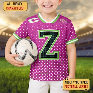May include: A magenta football jersey with white polka dots and a large green and black plaid "Z" on the front. The jersey has green and white trim and the text "ALL DISNEY CHARACTERS" and "ADULT/YOUTH/KID FOOTBALL JERSEY". A soccer ball is held in front.