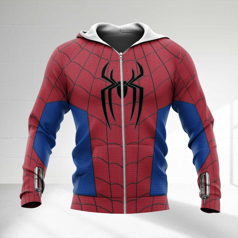 May include: A red and blue zip-up hoodie with a white hood. The hoodie features a black spider emblem on the chest and a web pattern across the red sections. Blue panels are on the sleeves. The hoodie has a full zipper and silver accents.