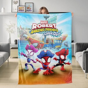K&ouml;nnte beinhalten: Eine gro&szlig;e, rechteckige Decke mit einer lebendigen Cartoon-Szene. Der Text "MARVEL ROBERT AMAZING FRIENDS WATER WEBS" ist zu sehen. Das Design zeigt drei Spider-Man-Charaktere, ein Piratenschiff und einen Hai vor blauem Himmel und Ozean.