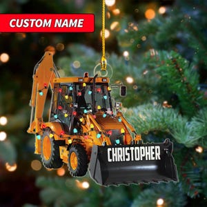 May include: A yellow construction vehicle Christmas ornament with the name "CHRISTOPHER" on the front bucket. The ornament is decorated with colorful string lights and the text "CUSTOM NAME" is at the top.
