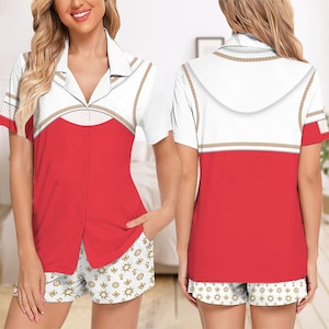 May include: A two-piece pajama set featuring a white top with red accents and gold trim, paired with matching shorts. The top has a button-down front and short sleeves. The shorts have a white background with gold sun and star patterns.