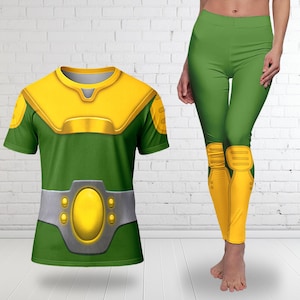 Puede incluir: Disfraz de superh&eacute;roe verde y amarillo, que incluye una camiseta de manga corta y leggings. La camiseta presenta un cuello y un peto amarillos, con un dise&ntilde;o de cintur&oacute;n plateado. Los leggings tienen rodilleras amarillas.