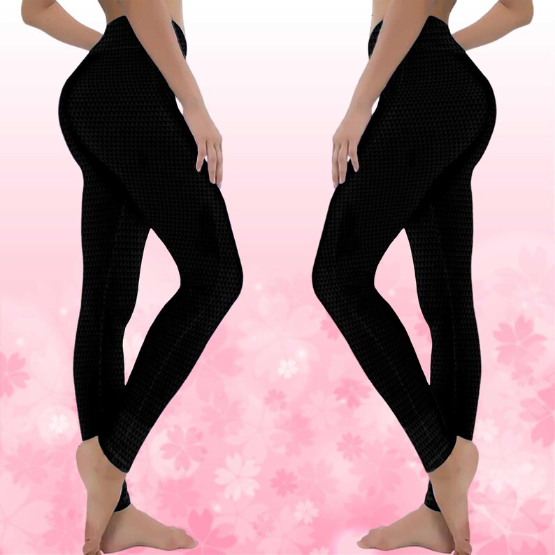 May include: Black leggings with a textured pattern. The leggings are form-fitting and reach the ankles. The background is a soft pink with white flower shapes.