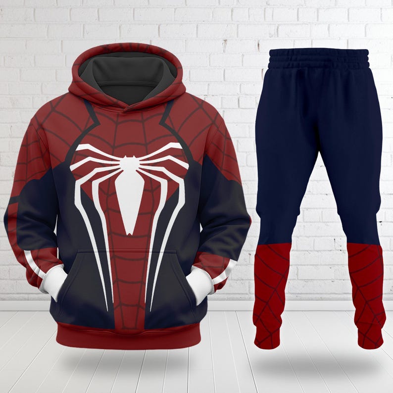 Puede incluir: Un conjunto de dos piezas con una sudadera con capucha y pantalones a juego con el tema de Spider-Man, en rojo, negro y blanco. La sudadera tiene un gran emblema de ara&ntilde;a blanco en el pecho y un dise&ntilde;o rojo y negro. Los pantalones son azul marino con detalles en rojo.