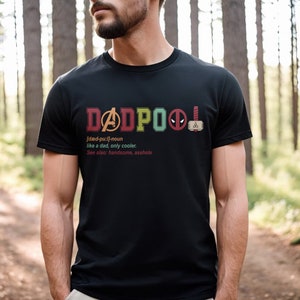 May include: Black t-shirt with a colorful graphic that says "DADPOOL" with a definition and a few superhero logos.