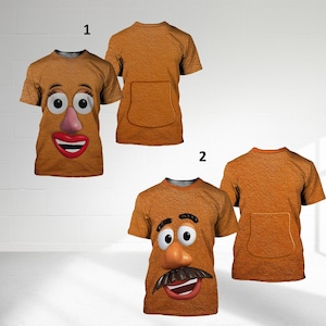 May include: Two brown t-shirts with a textured surface. One shirt features a cartoon face with large eyes, a pink nose, and a red mouth. The other shirt has a mustache and a smiling mouth. Both shirts have a pocket on the back.