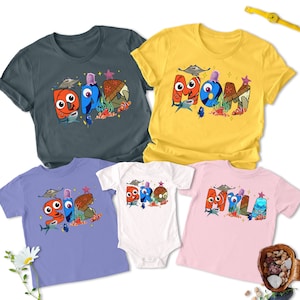 May include: A set of four t-shirts featuring Finding Nemo characters. The shirts are in different colours and feature the words "Dad", "Mom", "Bro", and "Myla".