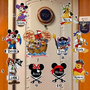 Op de afbeelding: Een verzameling Disney-thema piratendeurdecoraties. De decoraties tonen verschillende personages zoals Mickey Mouse, Minnie Mouse, Donald Duck en Stitch, elk met een piratenthema. Namen zijn op elke decoratie opgenomen.