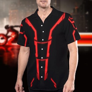 May include: Black button-down shirt with a red geometric design. The short-sleeved shirt features a classic collar and white buttons. The red design is a series of connected lines and shapes. The shirt is a casual style.