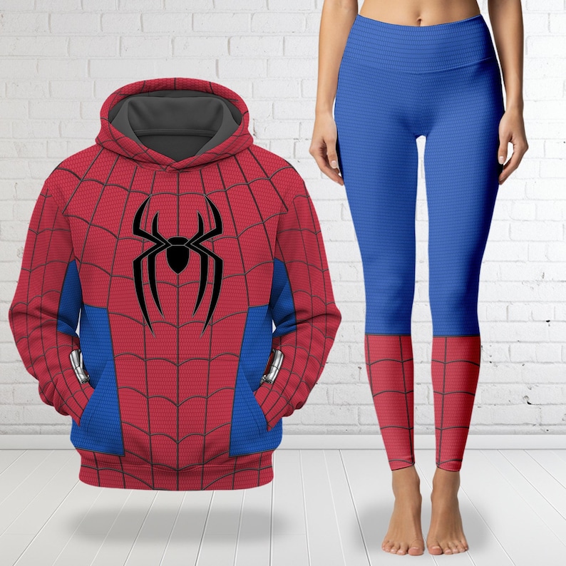 May include: A red and blue hooded sweatshirt featuring a black spider emblem and a web pattern, paired with matching blue leggings that have red web-patterned cuffs. The hoodie has a grey interior lining and blue side panels on the front.