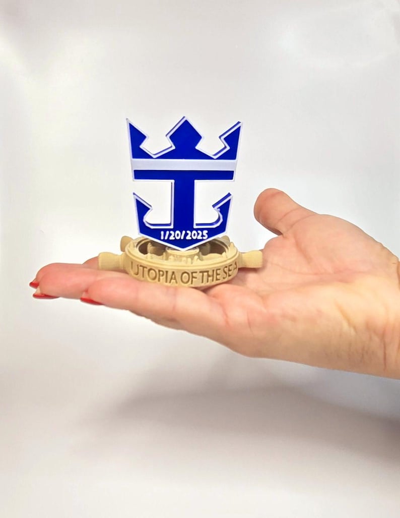 Peut inclure: Mod&egrave;le imprim&eacute; en 3D d'un gouvernail de navire de croisi&egrave;re avec le logo de Royal Caribbean International et le texte "Utopia of the Seas" ainsi que la date "1/20/2025".