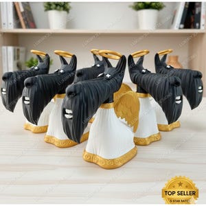 May include: A collection of black dog figurines with gold halos and wings, dressed in white robes with gold trim. The figurines have a Scottish Terrier appearance. The text "TOP SELLER" and "5-STAR RATED" is visible.