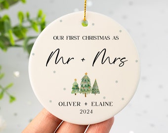 Può includere: Addobbo natalizio in ceramica bianca con il testo "Our First Christmas as Mr & Mrs Oliver + Elaine 2024" e un'illustrazione ad acquerello di tre alberi di Natale.