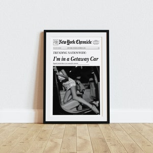Pode incluir: Uma fotografia a preto e branco de uma mulher num carro. A fotografia est&aacute; emoldurada e tem o t&iacute;tulo "I'm in a Getaway Car" do New York Chronicle.