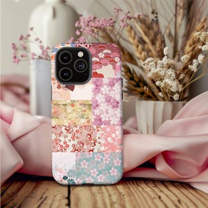 May include: A phone case with a patchwork design featuring pink, red, and gold floral patterns. The case has a camera cutout and is made of a durable material.