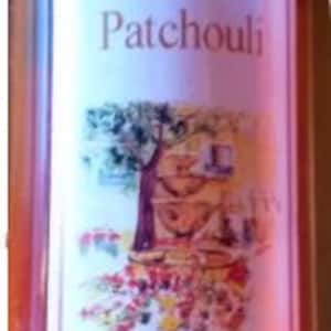 May include: A clear glass bottle of Patchouli Eau de Toilette from Grasse, France. The bottle contains a red liquid and has a silver cap. The label is white with black text and a floral illustration.