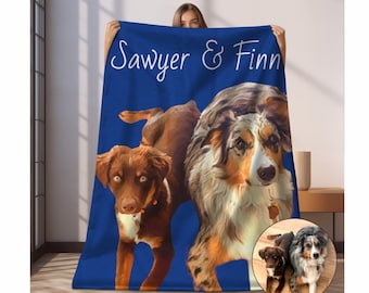 May include: A blue fleece blanket with a personalized design featuring two dogs. The dogs are a brown and white Australian Shepherd and a brown and white border collie. The text "Sawyer & Finn" is printed in white on the blanket.