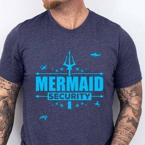 May include: A navy blue t-shirt with a blue trident and the text "Mermaid Security" printed on the front.