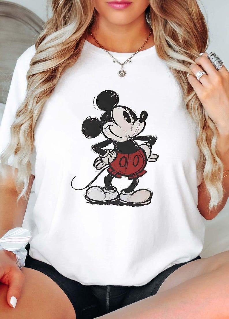 May include: White t-shirt with a black and white cartoon image of Mickey Mouse wearing red shorts.