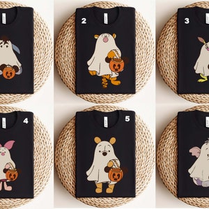 Celebrate spooky season with this Retro Winnie the Pooh Ghost Halloween Shirt featuring Pooh and friends in cute ghost costumes. Perfect for Disney lovers and fall festivities, this tee offers a soft, vintage vibe for Halloween events, family matching outfits, or cozy autumn days. Ideal for fans of classic characters and Halloween fun.