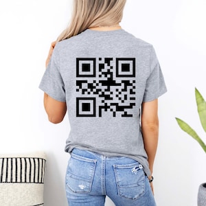 May include: A gray t-shirt with a black QR code printed on the back.