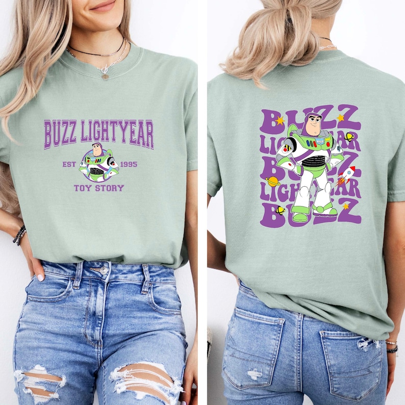 May include: A light green t-shirt with a purple graphic of Buzz Lightyear from Toy Story. The front of the shirt says "Buzz Lightyear Est 1995 Toy Story". The back of the shirt has a repeated graphic of Buzz Lightyear with the text "Buzz Lightyear Buzz" in a retro font.