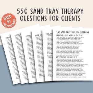 Puede incluir: Un montón de tarjetas de papel blanco con texto negro, titulado "550 Preguntas de terapia con bandeja de arena para clientes". Las tarjetas están organizadas por tema, incluyendo "Exploración", "Procesamiento" y "Seguridad e Identidad". Una pegatina roja dice "Usado por profesionales".