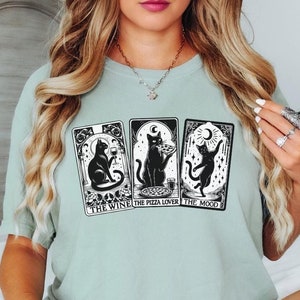 Camiseta divertida de tarot de gato negro. Camiseta de vino para amantes de la pizza. Elige gris, marfil, rosa, azul y negro. Ropa unisex personalizada, gótica y brujería.