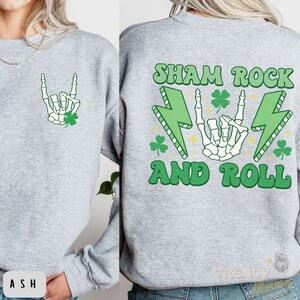May include: A gray sweatshirt with a green shamrock and skeleton hand graphic on the front and the text "Sham Rock and Roll" with a green shamrock and lightning bolt graphic on the back.