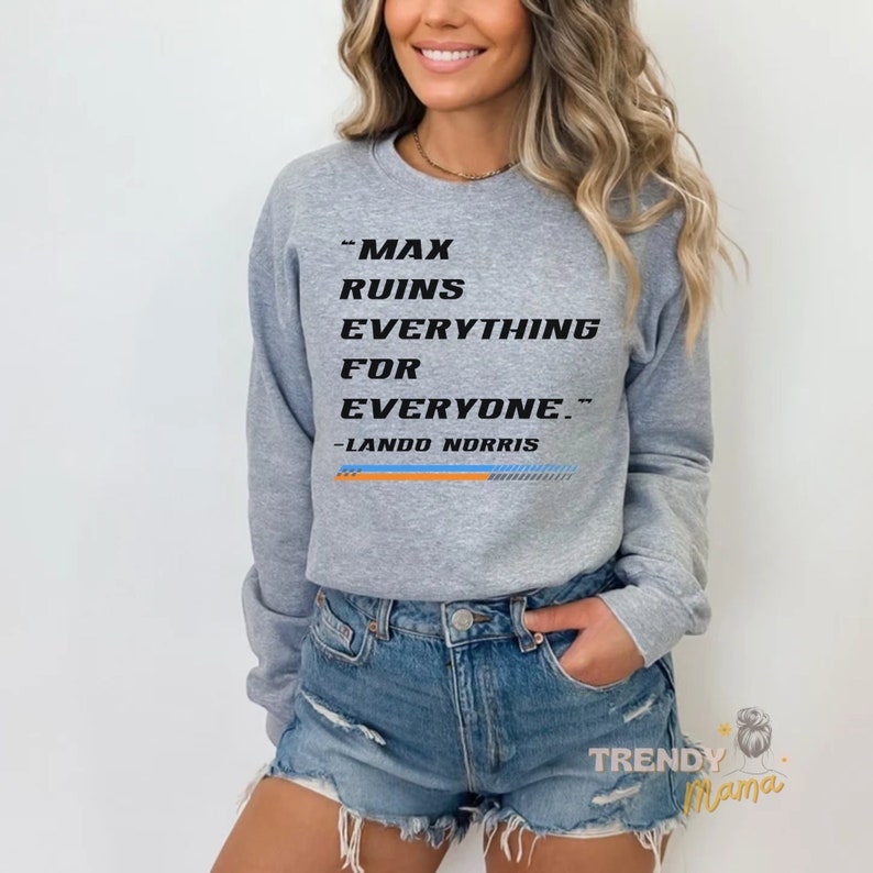 Peut inclure: Sweat-shirt gris avec le texte "Max ruins everything for everyone." et "Lando Norris" en noir. Le sweat-shirt est port&eacute; par une personne aux cheveux longs et bruns.