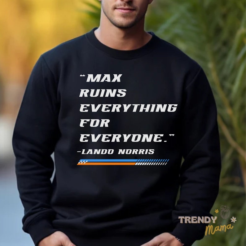 Peut inclure: Sweat-shirt noir avec un texte blanc qui dit "Max ruins everything for everyone." Le texte est suivi de "Lando Norris" en blanc plus petit. Une bande bleue et orange se trouve sous le texte.
