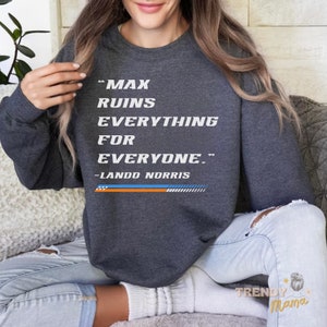 Peut inclure: Un sweat-shirt gris fonc&eacute; avec le texte "Max ruins everything for everyone." et "Lando Norris" imprim&eacute; sur le devant.