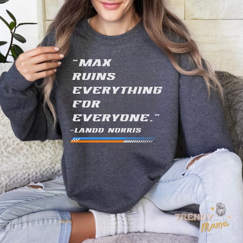 Peut inclure: Un sweat-shirt gris fonc&eacute; avec le texte "Max ruins everything for everyone." et "Lando Norris" imprim&eacute; sur le devant.