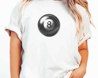 May include: A white t-shirt with a black and white 8-ball graphic.