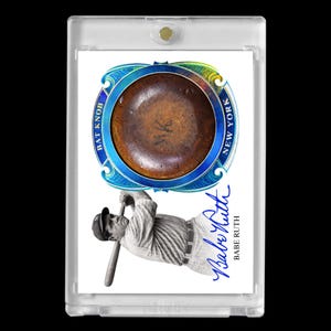 Può includere: Una carta da baseball con un pomello di mazza marrone con il testo "BAT KNOB NEW YORK" in un design blu e oro. La carta include anche un'immagine in bianco e nero di Babe Ruth e la sua firma.