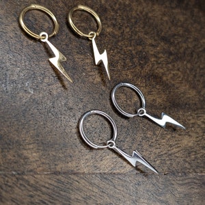 Pode incluir: Quatro pares de brincos com um charme de raio. Dois pares s&atilde;o dourados e dois pares s&atilde;o prateados.