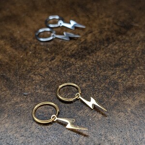 Pode incluir: Dois pares de brincos com um design de raio. Um par &eacute; dourado e o outro &eacute; prateado.