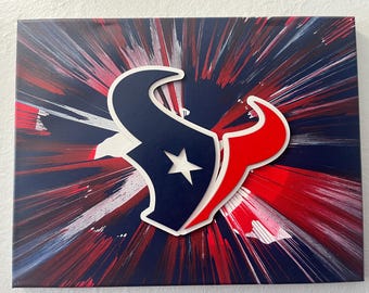 Könnte beinhalten: Leinwandkunst mit dem Logo der Houston Texans in Marineblau, Rot und Weiß. Das Logo ist über einem Hintergrund mit einem radialen Burst-Design in Rot, Weiß und Marineblau angeordnet. Das Kunstwerk ist auf einer rechteckigen Leinwand montiert.