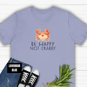 May include: Lavender blue t-shirt with a cartoon crab and the text "Be Happy Not Crabby".