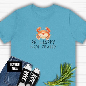 May include: A light blue t-shirt with a cartoon crab and the text "Be Happy Not Crabby".