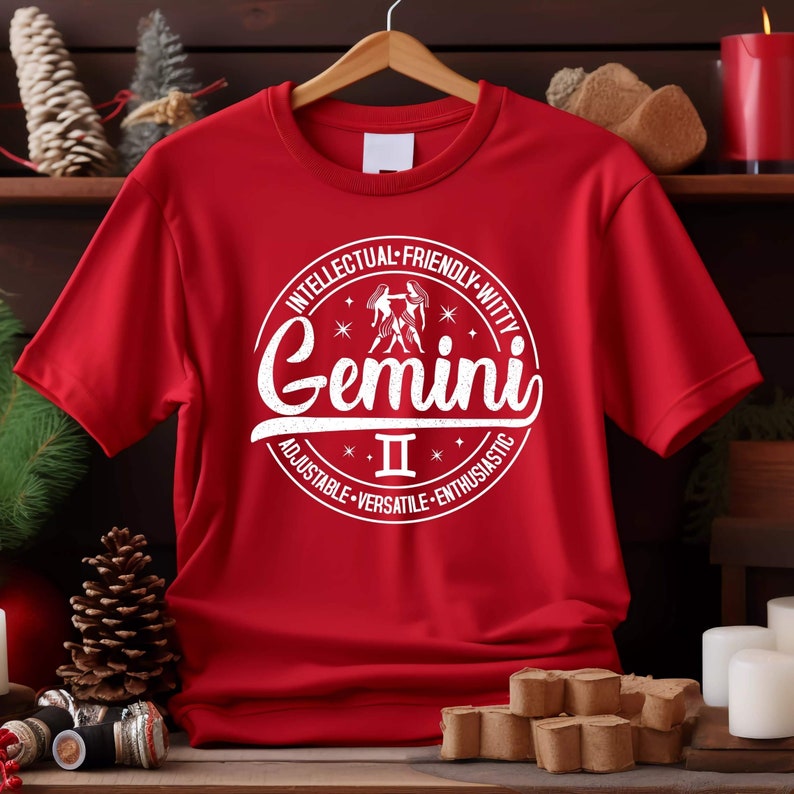 May include: Red t-shirt with a white circle graphic featuring the Gemini zodiac sign, the Roman numeral II, and the words "Intellectual-Friendly-Witty", "Gemini", "Adjustable-Versatile-Enthusiastic".