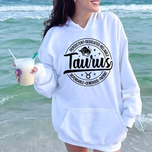 May include: White hoodie with a black circle graphic featuring the zodiac sign Taurus. The graphic includes the text "Taurus" and the words "Persistent, Dedicated, Reliable, Dependable, Generous, Patient".