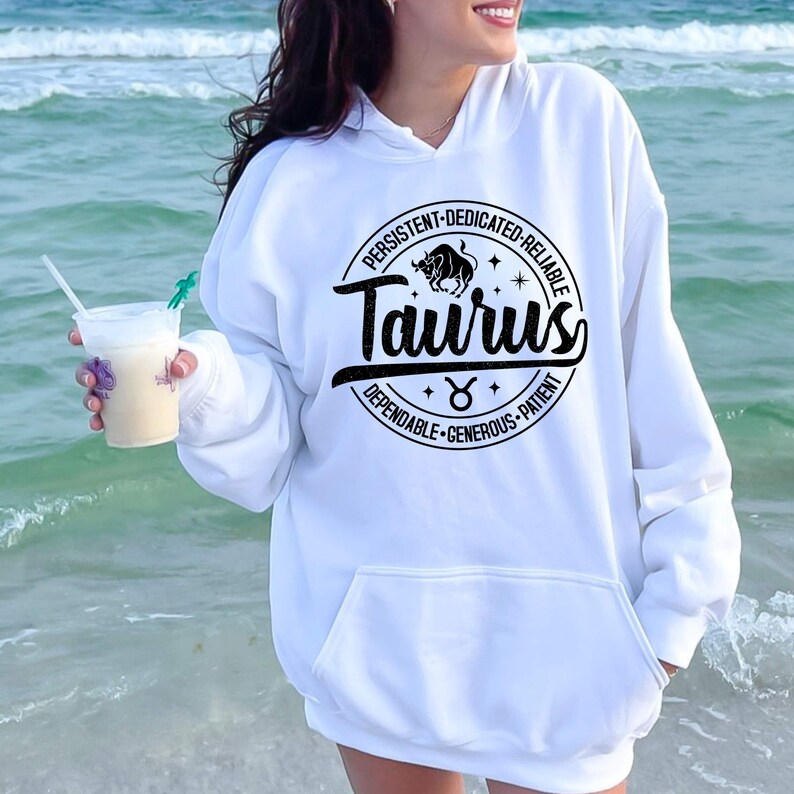 May include: White hoodie with a black circle graphic featuring the zodiac sign Taurus. The graphic includes the text "Taurus" and the words "Persistent, Dedicated, Reliable, Dependable, Generous, Patient".