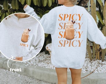May include: Light gray sweatshirt with the word "SPICY" in orange block letters on the back, along with a graphic of a drink. The front of the sweatshirt has a smaller graphic of the drink and the word "SPICY".
