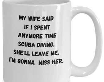Puede incluir: Taza de café de cerámica blanca con texto negro que dice: "Mi esposa dijo que si pasaba más tiempo buceando, me dejaría. La voy a extrañar."