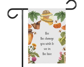 Puede incluir: Una bandera de jardín con un soporte de metal negro. La bandera presenta un diseño de acuarela con abejas, miel y el texto "Bee the change you wish to see in the hive". La bandera está rodeada de ilustraciones de plantas y flores.